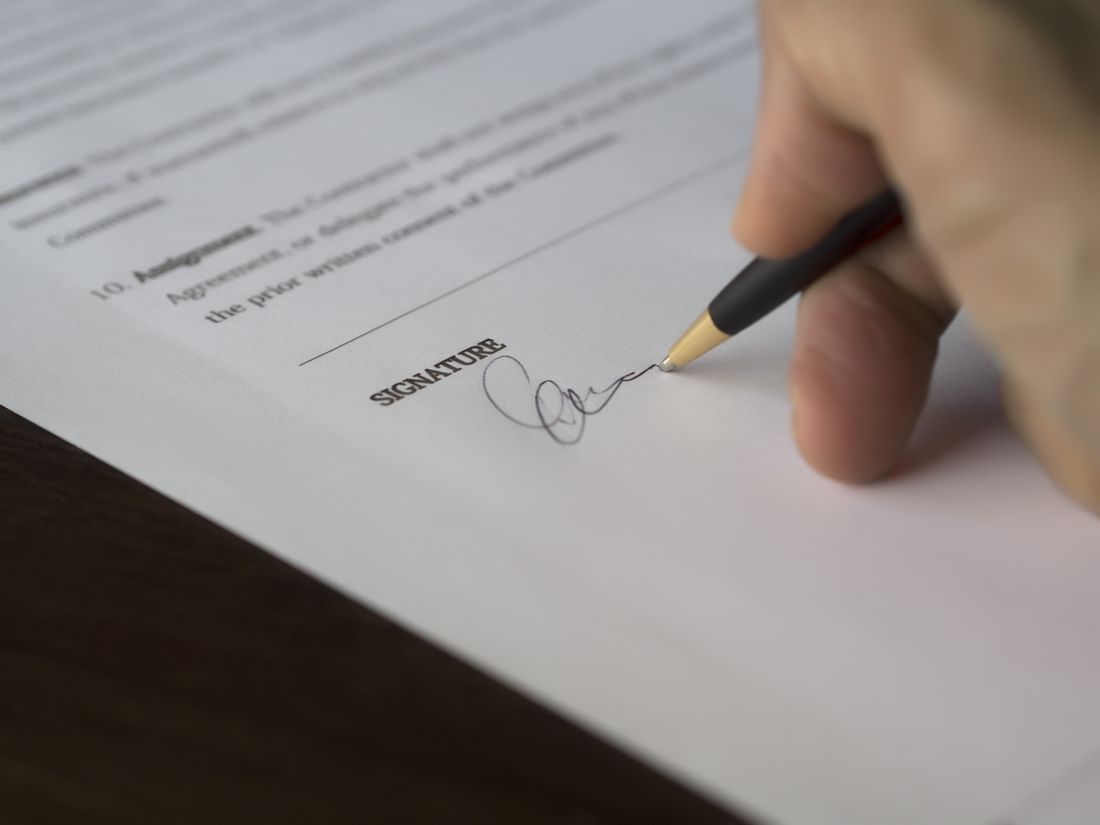 A hand signing a legal document